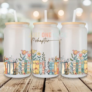 May include: Three white insulated tumblers with lids and straws. The tumblers feature a design of colorful books with flowers and the text "Just one more chapter".
