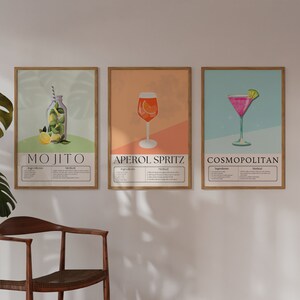 May include: Three framed illustrations of popular cocktails: a Mojito, Aperol Spritz, and Cosmopolitan. Each illustration features a colorful depiction of the drink and includes a list of ingredients and instructions.