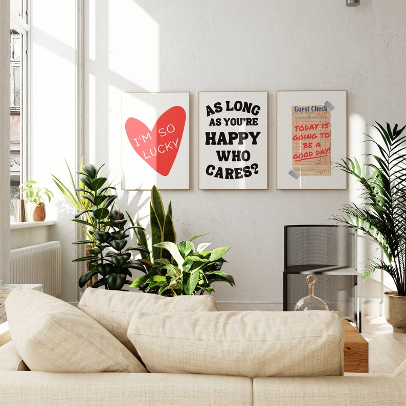 May include: Three framed prints with motivational quotes. The first print has a red heart with the text "I'm so lucky". The second print has the text "As long as you're happy who cares?" The third print has the text "Today is going to be a good day!"
