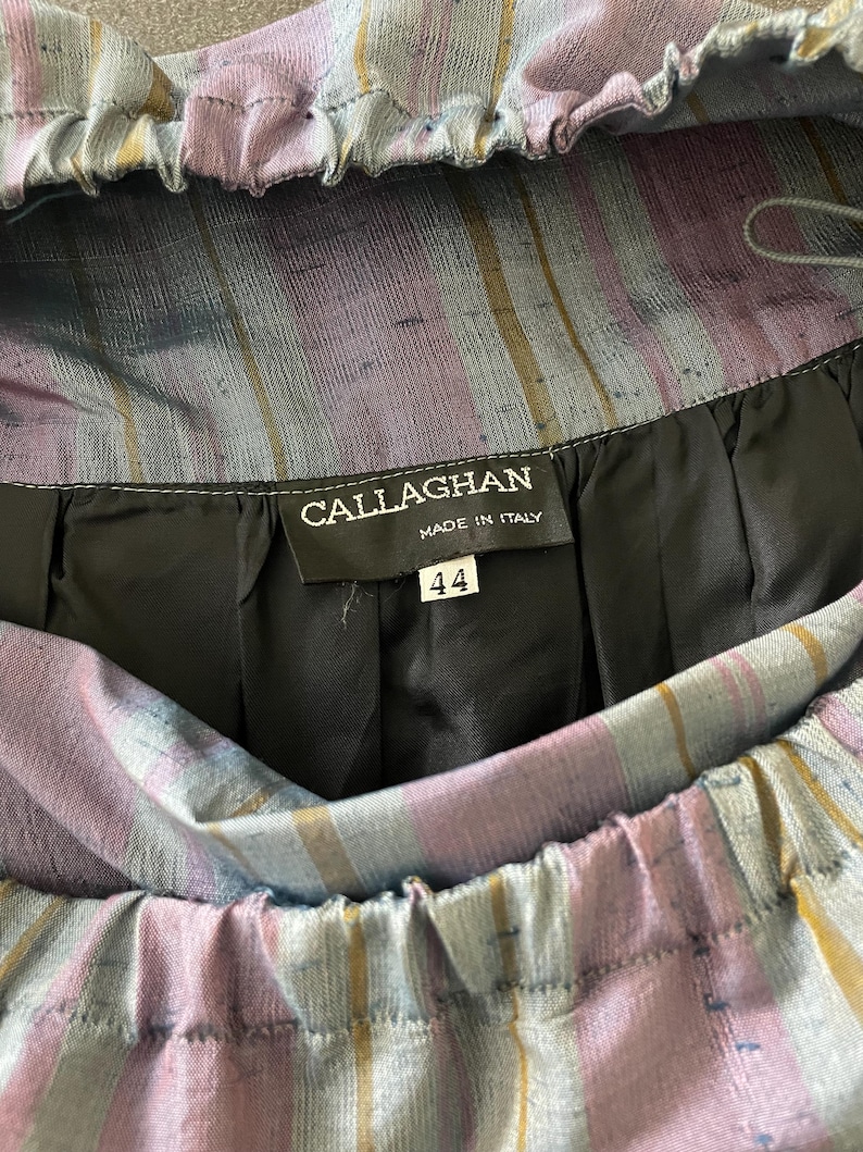 Może przedstawiać: Sp&oacute;dnica w niebiesko-fioletowe paski z czarną metką z napisem "CALLAGHAN MADE IN ITALY" i numerem "44".