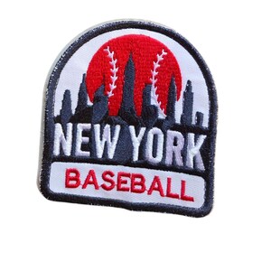 May include: A dome-shaped embroidered patch featuring a black silhouette of the New York City skyline against a red baseball graphic. The text NEW YORK is stitched in white, and the word BASEBALL is stitched in red on a white background.