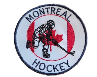 May include: Embroidered patch featuring a hockey player in red and black, set against a Canadian flag design. The patch is circular, with the words "MONTREAL" and "HOCKEY" in a blue font, and a black border.