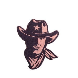 Op de afbeelding: Geborduurde patch met het gezicht van een cowboy met een hoed met een ster. Het ontwerp is in zwart en roze tinten, met gedetailleerde steken. Ideaal voor jassen of tassen.
