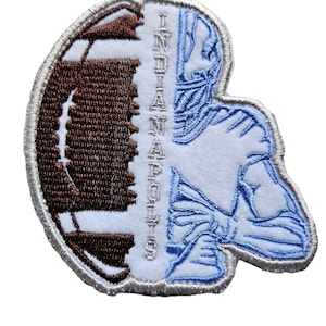 May include: A white and blue embroidered patch with a football and a football player. The text "INDIANAPOLIS" is written vertically on the patch.
