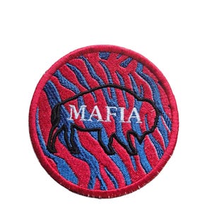 May include: A red and blue embroidered patch with a black silhouette of a buffalo and the word "MAFIA" in white text.