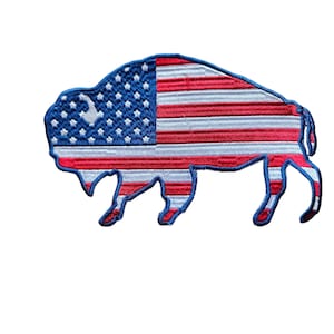 May include: An embroidered patch shaped like a bison with the American flag design. The bison is outlined in blue and the flag is red, white, and blue.