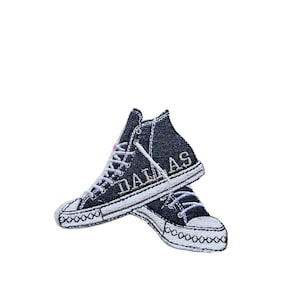 May include: A pair of blue denim high-top sneakers with white stitching and the word "DALLAS" embroidered on the side.