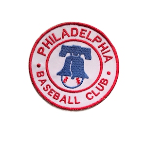 May include: Circular embroidered patch featuring the words "PHILADELPHIA BASEBALL CLUB" in red and white. The patch has a white background with a red border. The center design features a blue Liberty Bell and a baseball.