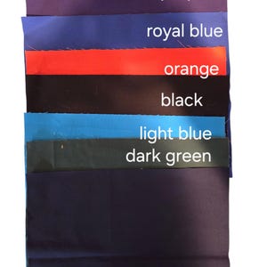 May include: A selection of fabric swatches in shades of purple, royal blue, orange, black, light blue, and dark green. Each swatch is labelled with its colour name in white text.