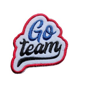 Può includere: Toppa ricamata con le parole "Go team" in scrittura blu e nera. La toppa ha uno sfondo bianco con un bordo rosso.