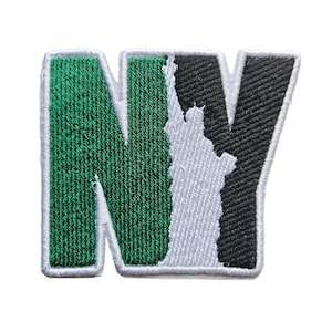 May include: Green and black embroidered patch with the letters "NY" in a stylized font. The "Y" is shaped like the Statue of Liberty.