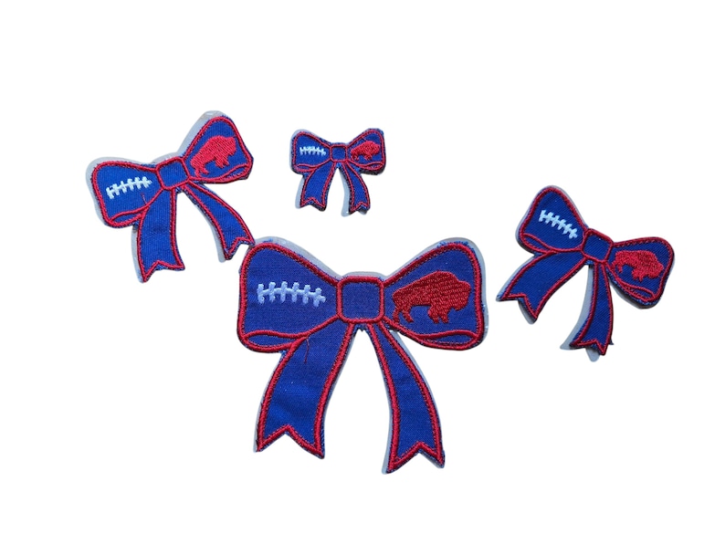 May include: Four blue and red decorative bows. The bows have a football design with white stitching and a red buffalo logo. The bows are in various sizes and are set against a white background.