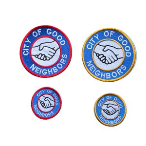 May include: Four circular embroidered patches featuring a white center with a black line drawing of two hands shaking. The blue border contains the text CITY OF GOOD NEIGHBORS in white. Two patches have a red border, and two have a gold border.