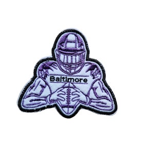 May include: Purple and black embroidered patch of a football player holding a football with the word "Baltimore" on the front.