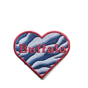 May include: Red heart-shaped patch with a blue and white zebra print and the word "Buffalo" embroidered in red.