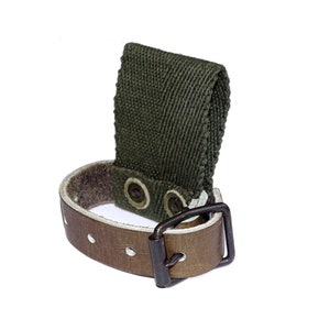 May include: A green canvas strap with a brown leather strap and buckle. The leather strap has two metal snaps and a metal buckle.