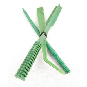 Może przedstawiać: Zestaw jasnozielonych narzędzi do ceramiki, w tym spiczaste narzędzie, narzędzie z ząbkowaną krawędzią i narzędzia z teksturowanymi uchwytami. Narzędzia są związane ciemnobrązową gumką, na białym tle.