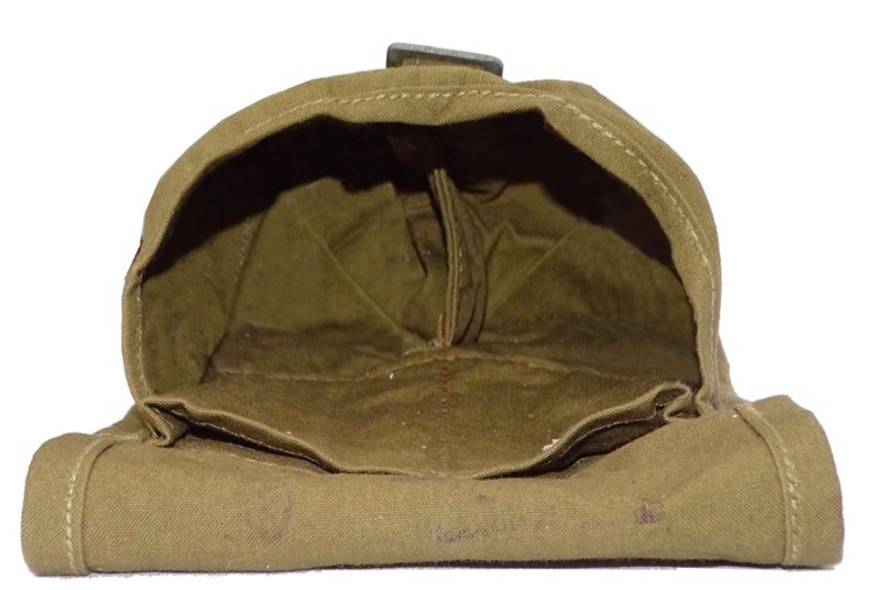 May include: An olive drab canvas pouch with a rectangular shape and a hinged flap. The interior is visible, showing a matching olive drab lining. A metal clasp secures the flap. The pouch appears to be vintage or military-style.