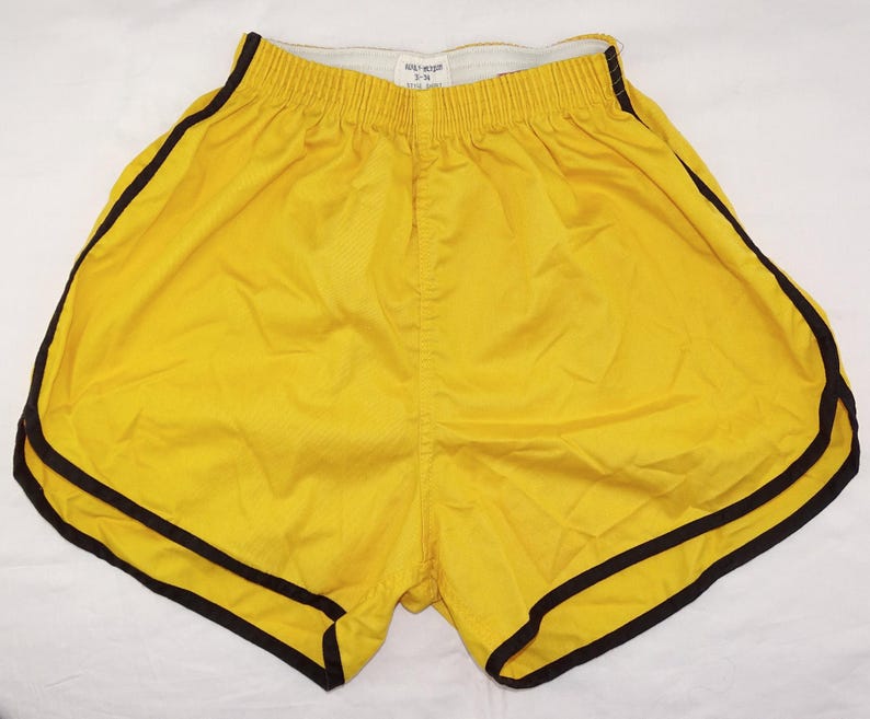 Pu&ograve; includere: Pantaloncini sportivi gialli con bordatura nera. I pantaloncini hanno un elastico in vita e un design retr&ograve; classico. Sono realizzati in un materiale leggero, perfetti per la corsa o altre attivit&agrave; sportive. I pantaloncini sono di colore giallo brillante.