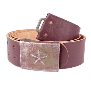 May include: A brown leather belt with a metal buckle featuring a five-pointed star. The buckle is worn and has a green patina.