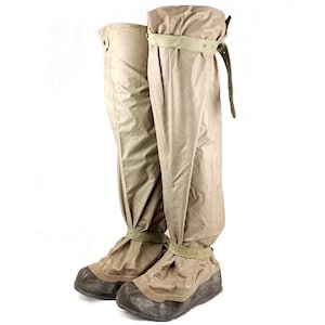 Peut inclure: Une paire de guêtres imperméables de couleur beige avec des sangles réglables. Les guêtres sont fabriquées dans un matériau léger et respirant et sont conçues pour garder vos pieds au sec par temps humide.