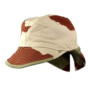 May include: A camouflage patterned military style hat with a brown, tan, and green colour scheme. The hat has a flap that can be folded down to cover the neck.
