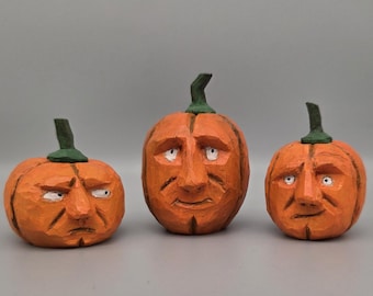Juego de tres calabazas de madera talladas a mano, estilo arte popular.
