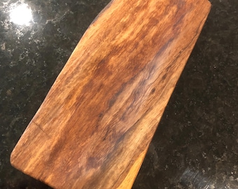 May include: A rectangular wooden serving tray with a natural wood finish. The tray has a slightly curved shape and a smooth surface.