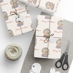 May include: Several wrapped gifts with a repeating snow globe pattern and the words "Merry Christmas." The gifts are tied with twine and adorned with white heart-shaped tags. A ball of twine, scissors, and additional tags are also present.