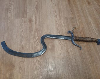 Espada khopesh egipcia de estilo fantasía y hoja forjada, endurecida y templada, con protector de raspado para mayor textura. Empuñadura a dos manos.