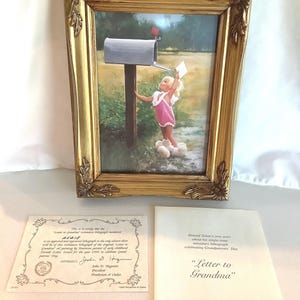 May include: A framed print of a young girl at a mailbox, with a gold ornate frame. The print is accompanied by a certificate and a booklet titled "Letter to Grandma". The artwork depicts a child in a pink outfit.