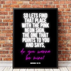 May include: Black and white typography print with the text "SO LETS FIND THAT PLACE WITH THE PINK NEON SIGN, THE ONE THAT POINTS TO YOU AND SAYS, do you wanna be mine?" in white text with the words "do you wanna be mine?" in pink text. The text is on a black background and the print has a black frame.