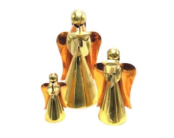Puede incluir: Tres figuras de ángeles dorados con alas de color cobre. Los ángeles son de diferentes tamaños, el más grande en el centro. Los ángeles tienen un diseño simple y elegante, perfecto para la decoración del hogar o como regalo.