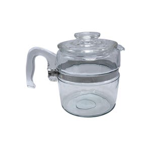 May include: Clear glass coffee pot with a glass lid and handle. The pot is held together with a silver metal band. The handle is curved and attached to the side of the pot. The lid has a small knob on top.
