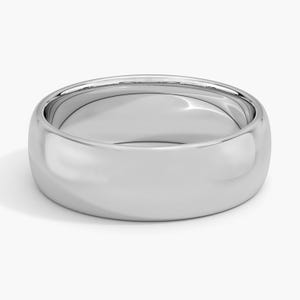 May include: A polished, silver-colored ring with a rounded band. The ring has a smooth, reflective surface, and the design is simple and elegant. The ring is likely made of a precious metal, such as silver or platinum.