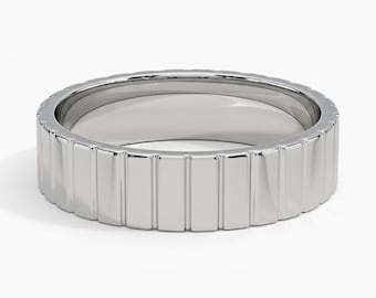 May include: A silver-colored ring with a rectangular, ridged design around the band. The ring is shown on a white background, highlighting its polished, reflective surface. The ring's design is modern and minimalist.