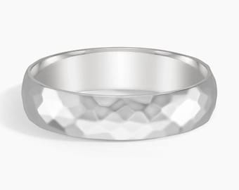 May include: A silver ring with a hammered texture. The ring has a rounded shape and a polished interior. The hammered design creates a faceted surface, reflecting light. This piece of jewelry is suitable for everyday wear.