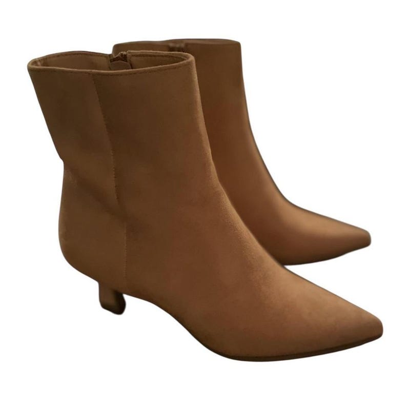 K&ouml;nnte beinhalten: Ein Paar hellbraune Stiefeletten mit spitzer Zehenpartie und kleinem Absatz. Die Stiefel haben eine Wildleder-&auml;hnliche Textur und einen Rei&szlig;verschluss an der Innenseite. Die Absatzh&ouml;he betr&auml;gt ca. 3,8 cm.