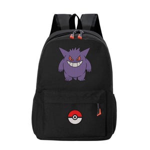 May include: A black backpack featuring a purple Gengar character graphic on the main compartment and a red and white Poké Ball icon on the front pocket. The bag includes black shoulder straps and orange zipper pulls on the main and front zippers.