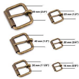 Może przedstawiać: Pięć antycznych klamerek do paska wykonanych z mosiądzu w różnych rozmiarach. Klamry mają rozmiary 50 mm, 25 mm, 40 mm, 20 mm i 16 mm.