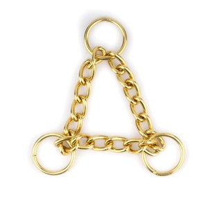 May include: A gold-coloured chain with three rings, forming a triangle shape. The chain is made of metal links.