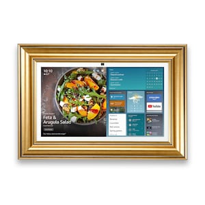 Puede incluir: Una pantalla digital rectangular enmarcada en oro, que muestra una colorida receta de ensalada y un pronóstico del tiempo. La pantalla muestra la hora, la temperatura y una lista de ingredientes. El marco es de color oro cálido.