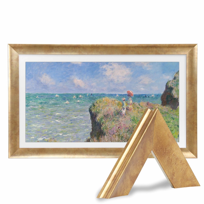 Puede incluir: Una pintura de paisaje enmarcada con un marco dorado. La pintura representa una escena costera con un oc&eacute;ano azul, veleros blancos y un acantilado cubierto de hierba con figuras. Una muestra de marco dorado est&aacute; en primer plano.