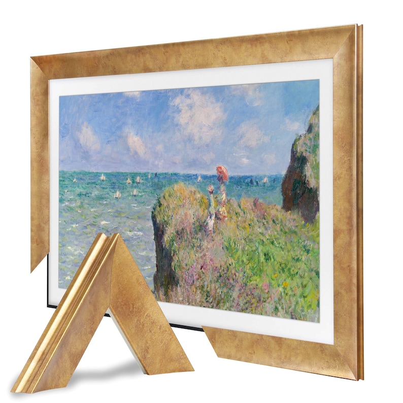 Puede incluir: Una impresi&oacute;n enmarcada de una pintura de paisaje costero. La obra representa una escena de acantilados con figuras, veleros en el agua y un cielo azul con nubes. El marco es de color dorado y tiene un acabado texturizado.