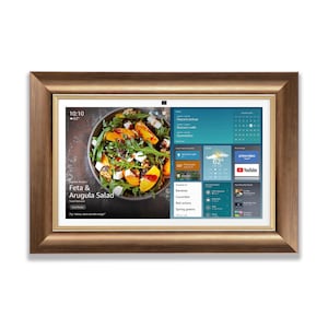 Könnte beinhalten: Ein rechteckiger digitaler Bildschirm mit Holzrahmen. Der Bildschirm zeigt ein Salat-Rezept, Wetterinformationen und App-Symbole. Das Rezept ist für Feta & Rucola-Salat. Die Uhrzeit ist 10:10 Uhr und die Temperatur beträgt 16.6 Grad Celsius.