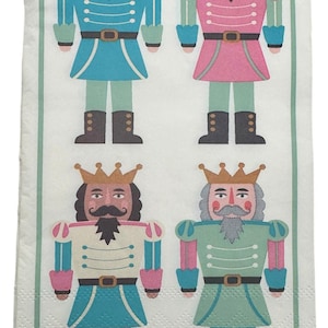 May include: A white paper napkin featuring four colorful nutcracker soldier illustrations. Each soldier wears a crown, a jacket in blue, pink, green, or cream, and black boots. The napkin has a green border and star accents.