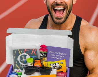 May include: A person holding a purple box filled with athletic supplements, sunglasses, and other items. The box contains energy gels, snacks, and a water bottle. The text on the box reads "When your legs get tired, run with your heart."