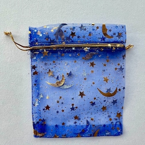May include: A blue mesh gift bag with a gold drawstring and a pattern of gold stars and crescent moons.