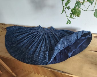 May include: A blue and white polka dot skirt with a gathered waist and a full skirt. The skirt is made of a lightweight fabric and has a lining.
