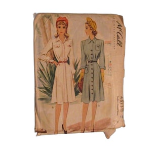 Peut inclure: Patron de couture vintage McCall's pour une robe femme. Le patron est pour une robe à boutons avec un col et des poches. Le patron est présenté sur deux mannequins, l'un portant une robe blanche et l'autre une robe bleue. Le numéro du patron est 4573.